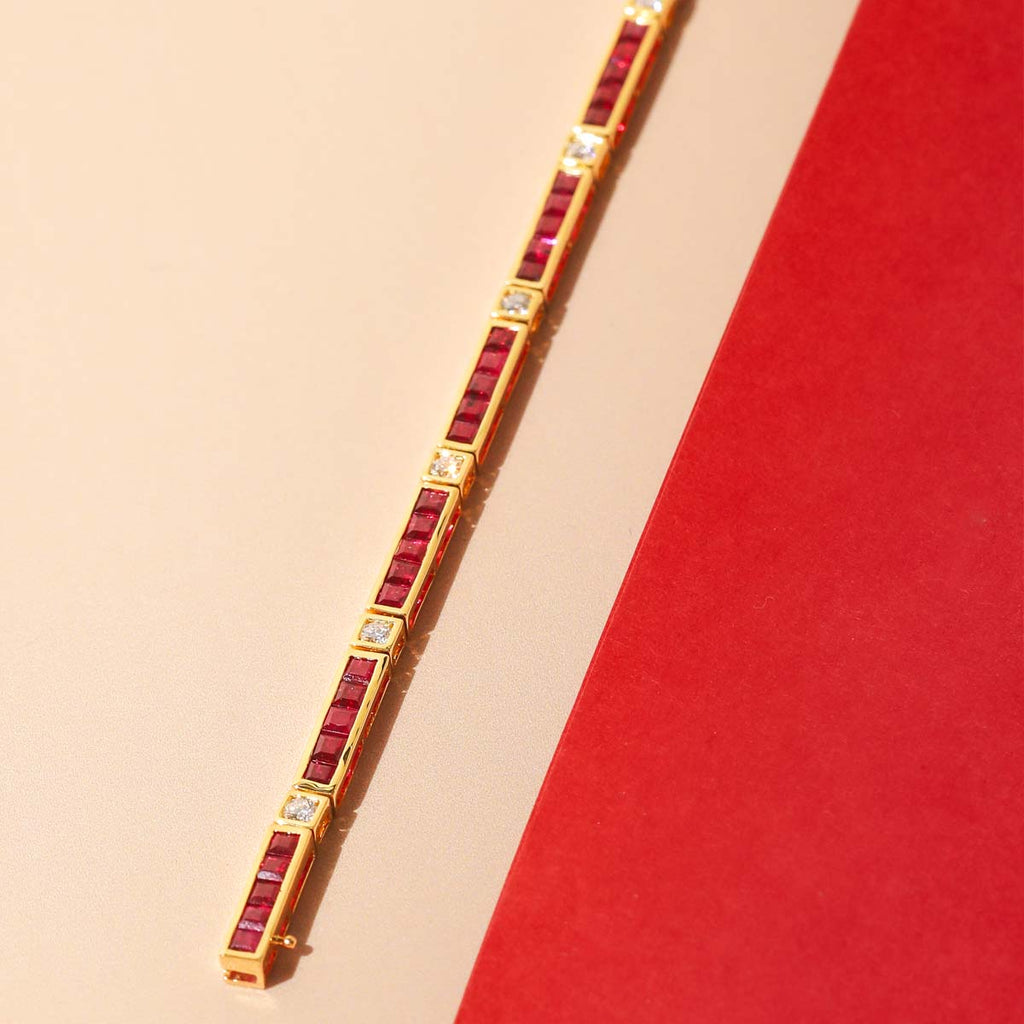 Gold bracelet with red stones on a beige and red background