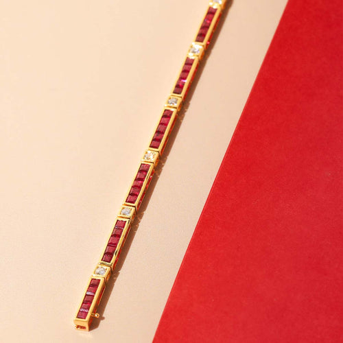 Gold bracelet with red stones on a beige and red background