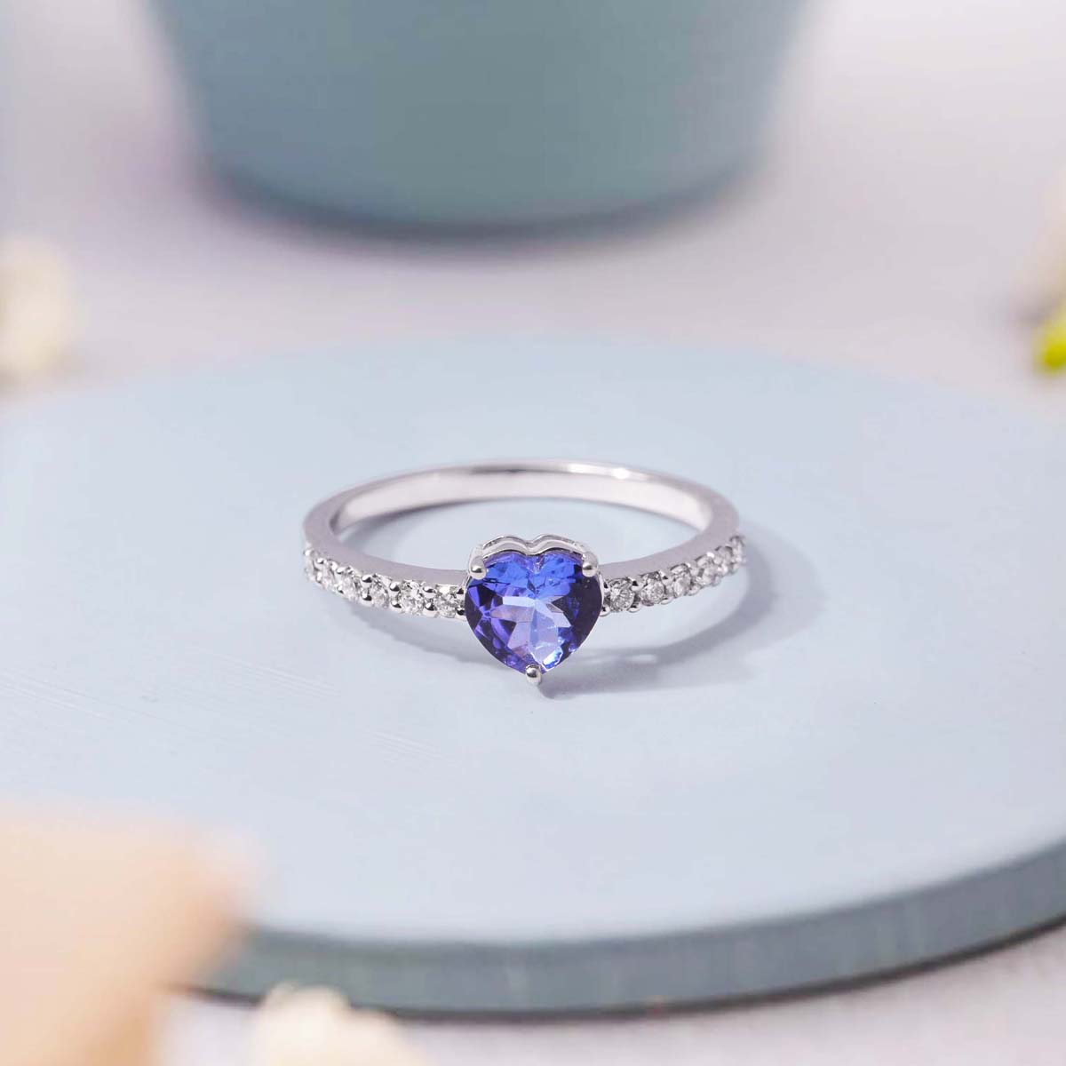 Silver ring with a heart-shaped blue gemstone on a light surface